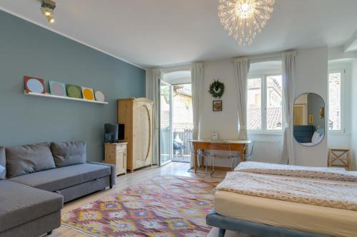 ein Schlafzimmer mit einem Bett und einem Sofa in der Unterkunft Sonnenuhr Bolzano Apartments in Bozen