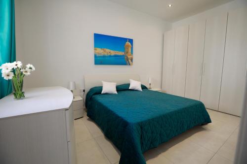 a bedroom with a bed and a vase of flowers at 3-bedroom Apartment with views in Iz-Zebbug, Gozo in Żebbuġ