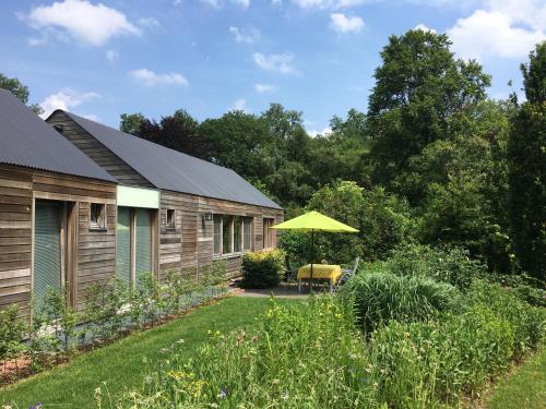 a garden with a house and a yellow umbrella at Nieuw Kagelink in Diepenheim