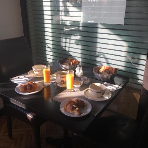 a table with plates of pastries and glasses of orange juice at Hôtel Restaurant Au Coucou in Pulversheim