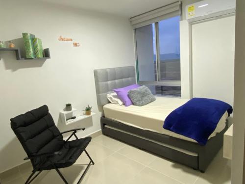 a bedroom with a bed and a chair and a window at Espectacular Apartamento VIP - 2 Hab. Ricaurte in Ricaurte