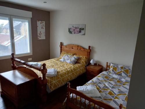 1 dormitorio con 2 camas y ventana en La boutique du vieux village en Le Mesnillard