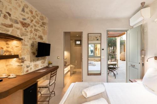 a hotel room with a king sized bed and a bathroom at Inotropes Boutique Suites - Adults Only in Archanes
