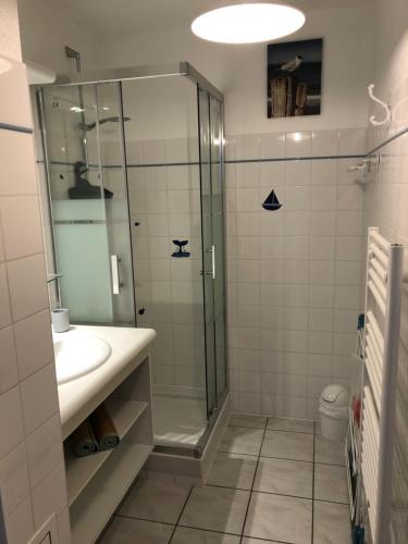 une salle de bain avec une douche en verre et un lavabo dans l'établissement Côté Bassin, à Arcachon