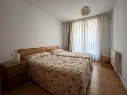 a bedroom with a large bed and a television at Casa Damián del Baile Apartamentos in Benasque