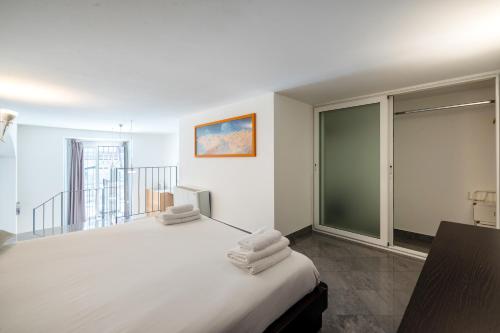 a bedroom with a large white bed with towels on it at Esclusivo Loft In Porta Romana, a 250m dalla Bocconi in Milan