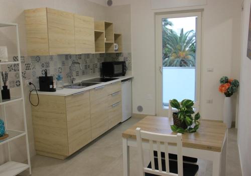 a kitchen with wooden cabinets and a table and a window at Romeo&Giulietta in Monopoli