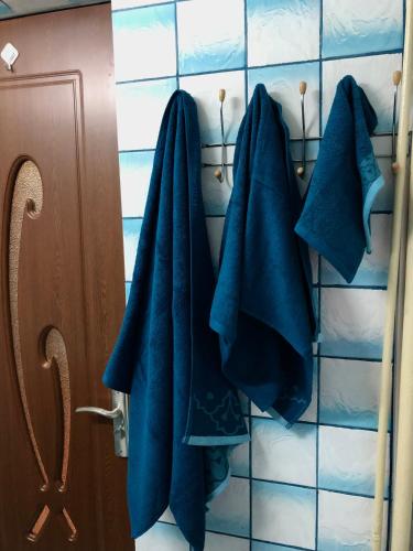 a bathroom with blue towels hanging on a wall at La SYMO apartament STRAJA Lupeni in Lupeni