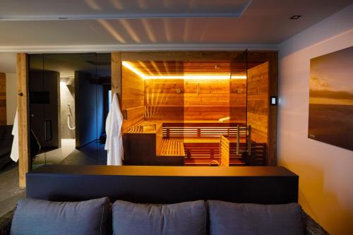 a living room with a couch and a large glass wall at Ansitz Brenner in Gmund am Tegernsee