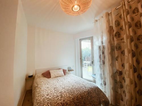 une chambre avec un lit et une grande fenêtre dans l'établissement 50m plage - 2 pièces jardin garage, à Cagnes-sur-Mer