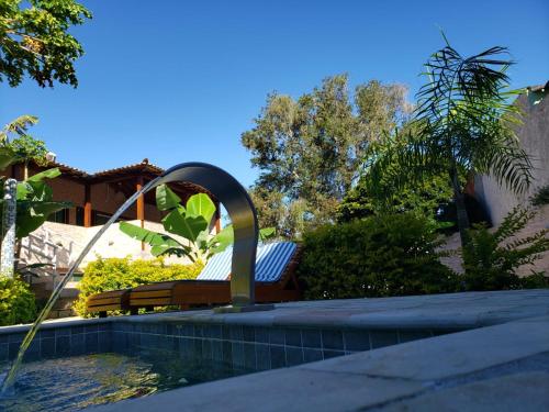 a pool with a bench and a water fountain at Recanto Praiana de Búzios in Búzios