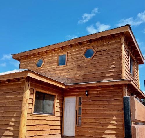 Casa de madera con puerta blanca en Cabañas Trabun-Leufu, en La Unión