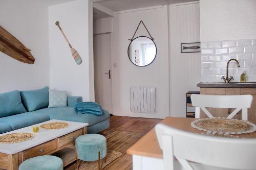 sala de estar con sofá azul y mesa en Le 8 ∙ Appartement cosy avec balcon vue sur mer, en Mers-les-Bains