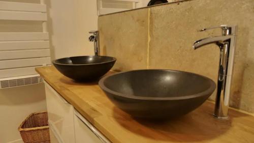 a bathroom with a black bowl sink on a counter at Appartement T3 in Rennes