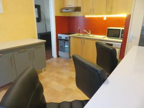 - une cuisine avec un comptoir et des chaises dans la chambre dans l'établissement Appartement T3, à Rennes