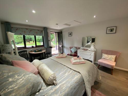 a bedroom with two beds and a table and chairs at Pinewood Lodge in Ibstock