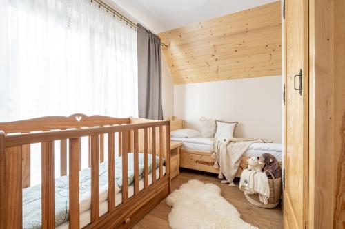 a nursery with two twin beds and a window at Domek Chatka Góralki in Poronin