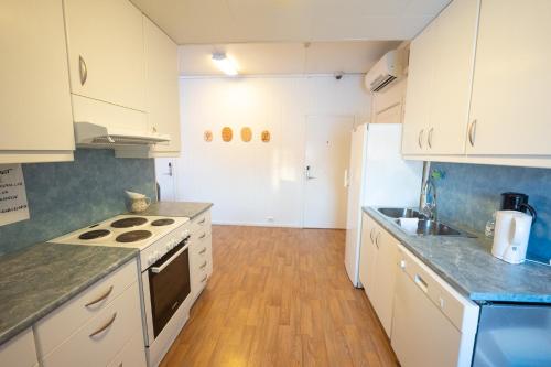 a kitchen with white cabinets and a stove top oven at Mix Tana Spiseri og Overnatting in Tana