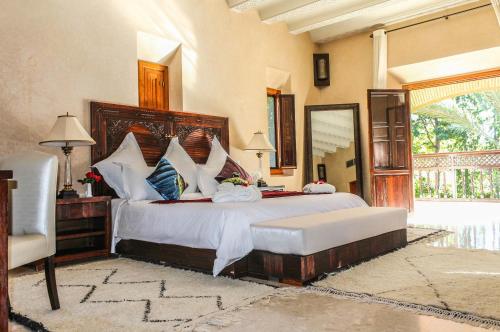 a bedroom with a large bed and a mirror at Magnificent Villa "Golf Amelkis" in Marrakech