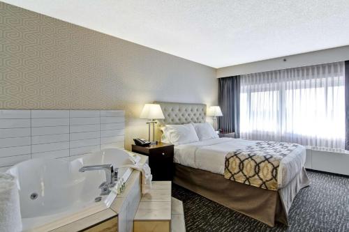 - une chambre d'hôtel avec un lit et une baignoire dans l'établissement Best Western Cedar Park Inn, à Edmonton
