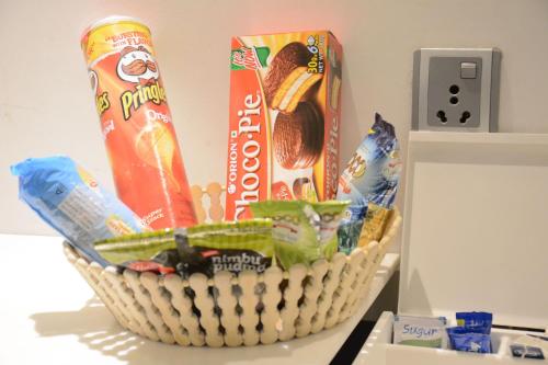 a basket of food and snacks on top of a refrigerator at Hotel Grand Godwin - Free Airport Pick-Up in New Delhi