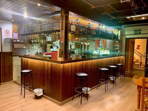 een bar met barkrukken in een restaurant bij Hostal Mainz in Piedralaves