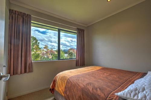 een slaapkamer met een bed en een groot raam bij 9a Tarndale Place in Hanmer Springs