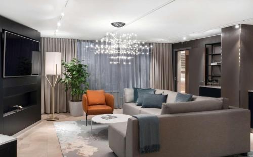 a living room with a couch and a chandelier at Radisson Blu Royal Hotel, Helsinki in Helsinki