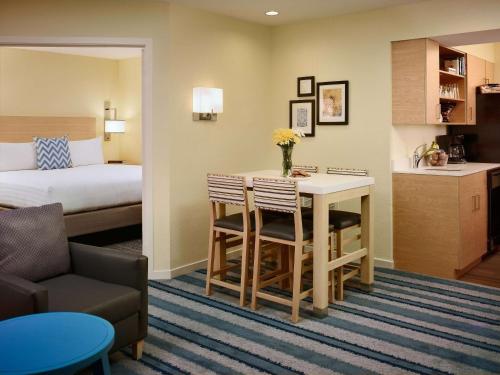 プリンストンにあるソネスタ ES スイーツ プリンストンのベッド、テーブル、椅子が備わるホテルルームです。