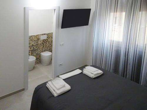 una camera da letto con un letto e due asciugamani di SMART Rooms Pistoia a Pistoia