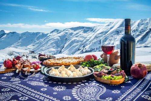 a table with food and a glass of wine at Best Western Gudauri in Gudauri