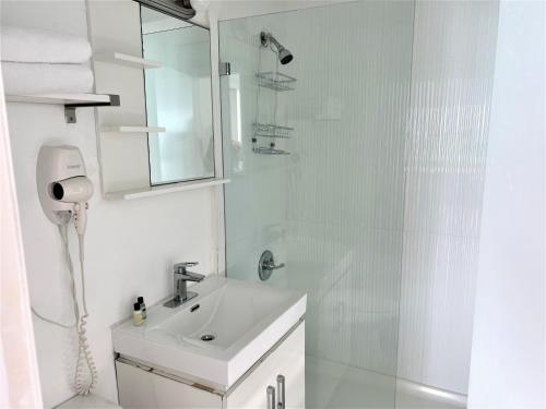 a white bathroom with a sink and a shower at Ocean Front Units at Miami Beach in Miami Beach