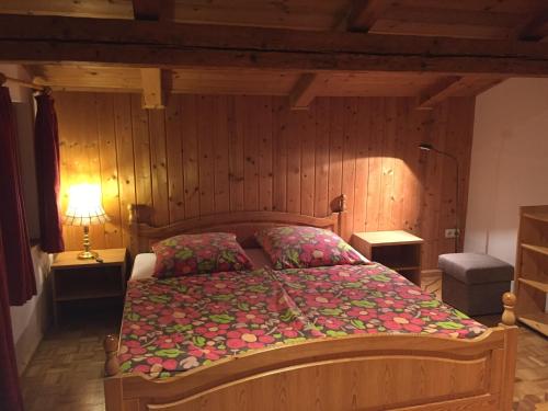 ein Schlafzimmer mit einem Bett in einem Zimmer mit Holzwänden in der Unterkunft Ferienhaus Zopfhäusl in Böbrach