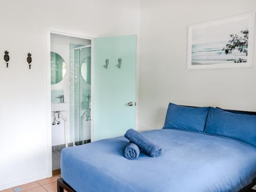 uma cama azul com uma almofada azul em cima em Wake Up! Byron Bay em Byron Bay