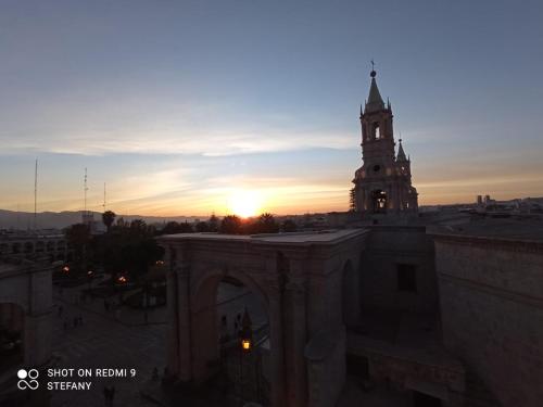 un edificio con una torre de reloj con la puesta de sol en el fondo en Catedral, en Arequipa