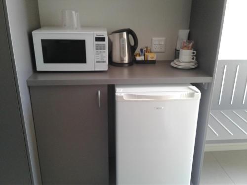 un bancone cucina con forno a microonde e frigorifero. di Royal Motel Miles a Miles