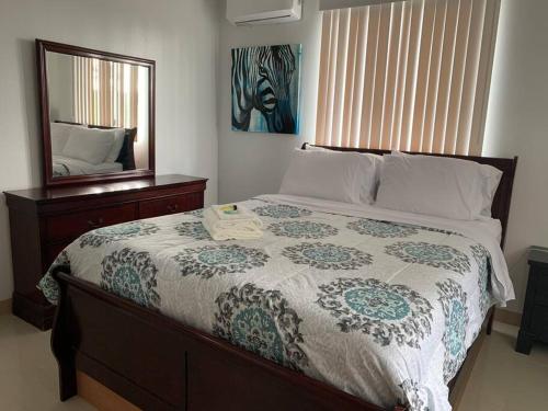 a bedroom with a large bed and a mirror at Private/Central 3 Bedroom Home in Hagatna