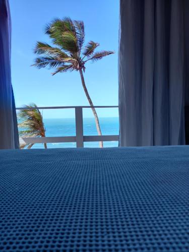 a room with a view of a palm tree and the ocean at Aloha in Icapuí