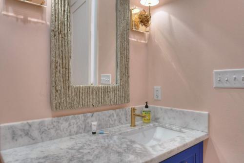 a bathroom with a sink and a mirror at The Pink Room at Emily's On The Island in Galveston