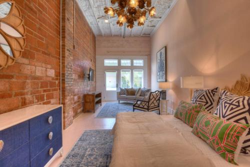 uma sala de estar com um sofá e uma parede de tijolos em The Pink Room at Emily's On The Island em Galveston