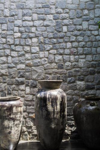 three large vases sitting in front of a brick wall at Clay Beach Samui - Beachfront Villas in Amphoe Koh Samui