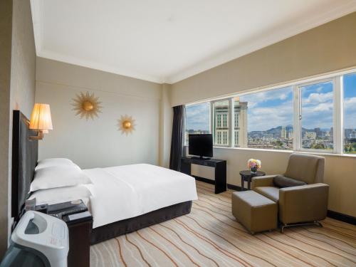 a hotel room with a large bed and a window at Grand Park Kunming in Kunming