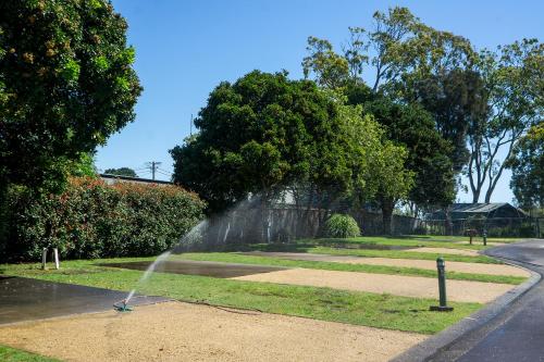 a water sprinkler system shooting water into the grass at Thou Walla Sunset Retreat in Soldiers Point