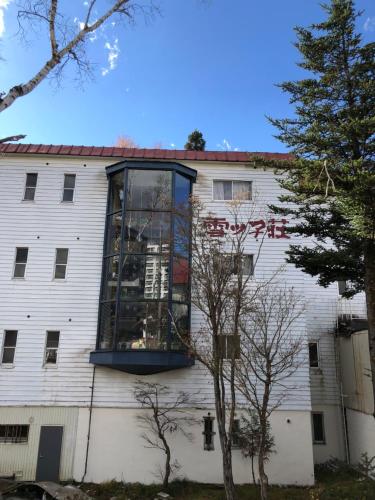 un bâtiment avec une grande fenêtre sur son côté dans l'établissement Petit Hotel Yukikkoso, à Yuzawa