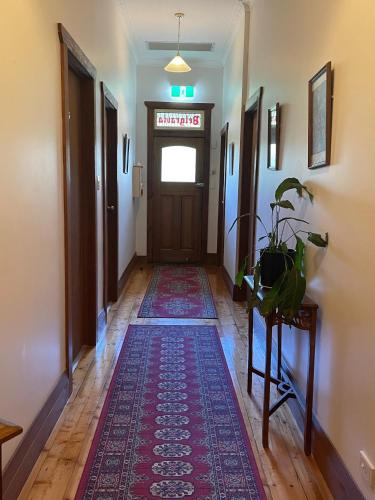 a hallway with a rug in front of a door at Belgravia Mountain Guest House in Katoomba