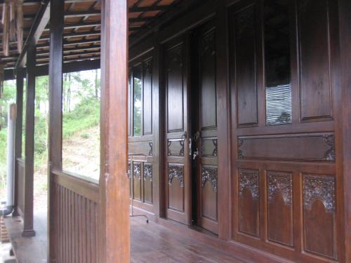 Habitación con puertas de madera y suelo de madera. en Villa Borobudur Malino, 