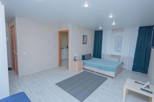 ニジニ・タギルにあるApartments on Lenina 26のベッドルーム(青いベッド1台、窓付)