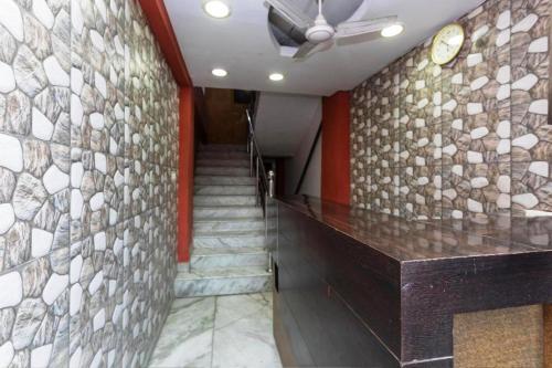 a lobby with a stone wall and a staircase at Hotel Thakur Shri in Bhopal