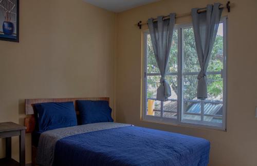 Un dormitorio con una cama azul y una ventana en HOTELITO SAN IGNACIO, en San Ignacio