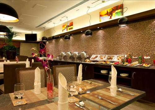 a dining room with a table and a counter with food at Sunday Marina View Hotel Apartments in Dubai